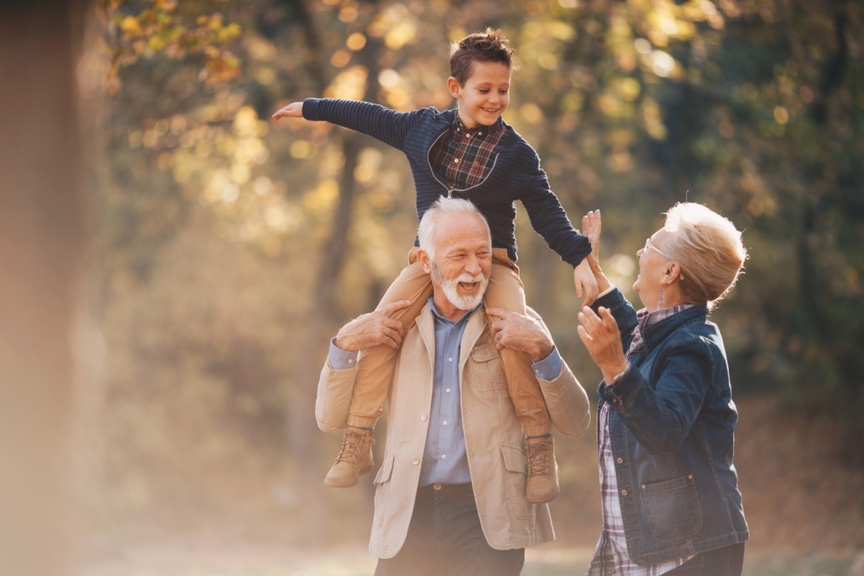 Grandparents having a lovely autumn day with their grandson in nature